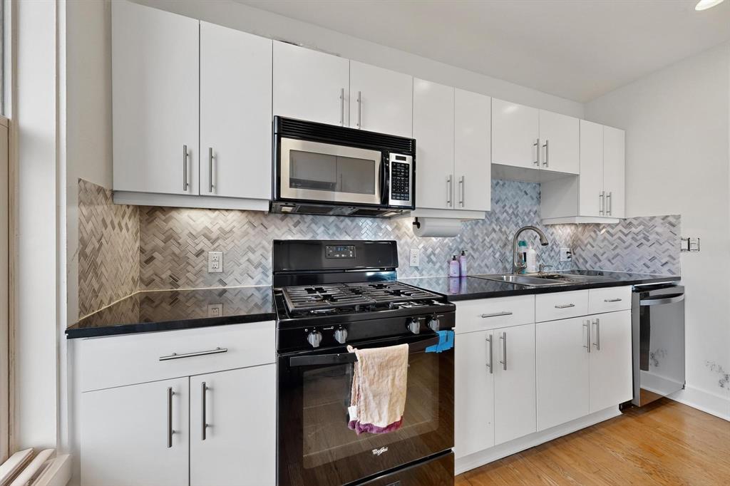 5055 Addison Circle, Unit 736 Addison, TX 75001 - Photo 14 of 34 a kitchen with granite countertop white cabinets sink and stainless steel appliances