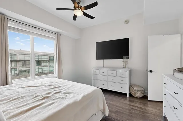a bedroom with a bed and a flat tv screen on dresser