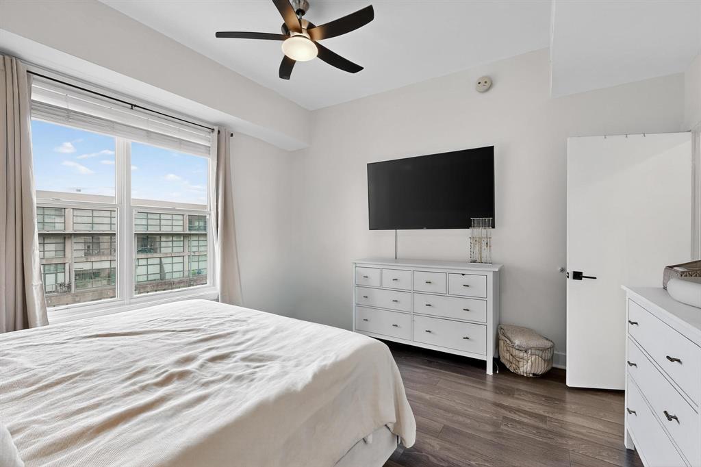 5055 Addison Circle, Unit 736 Addison, TX 75001 - Photo 19 of 34 a bedroom with a bed and a flat tv screen on dresser