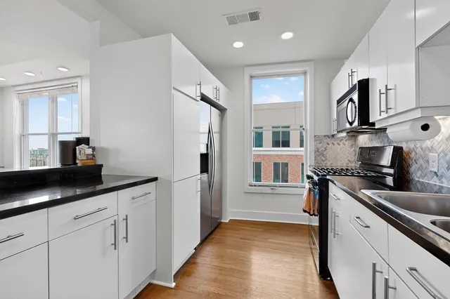 a kitchen with stainless steel appliances granite countertop a refrigerator and a sink