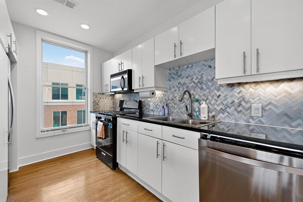 5055 Addison Circle, Unit 736 Addison, TX 75001 - Photo 9 of 34 a kitchen with stainless steel appliances granite countertop a sink a stove and a refrigerator