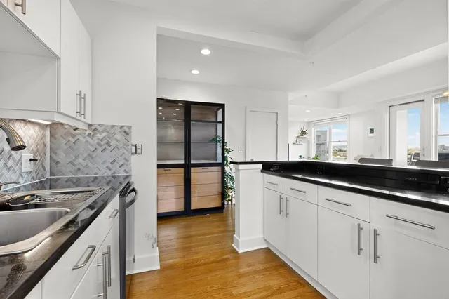 a kitchen with stainless steel appliances granite countertop a sink stove and cabinets