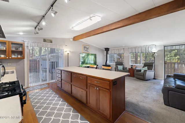 a large kitchen with kitchen island a large counter space a sink stainless steel appliances and cabinets