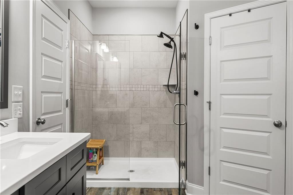 3696 Lee Road Salem, AL 36874 - Photo 24 of 36 Walk-in shower with clear glass enclosure, tile surround, and dual shower heads