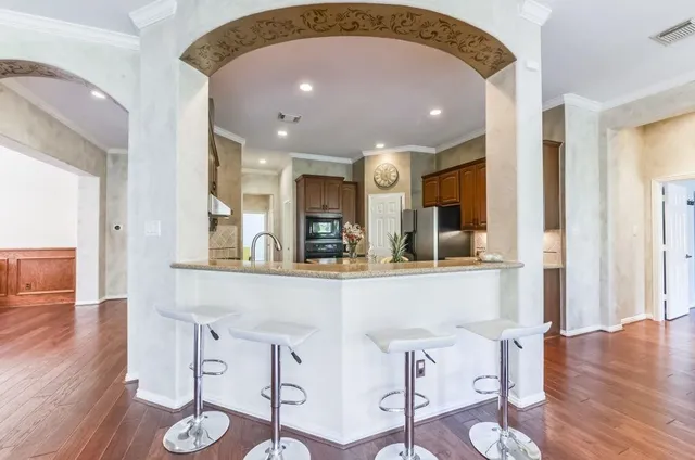 a view of a dining room with furniture a chandelier and wooden floor