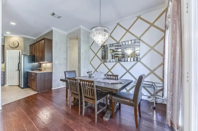a dining room with furniture a chandelier and wooden floor