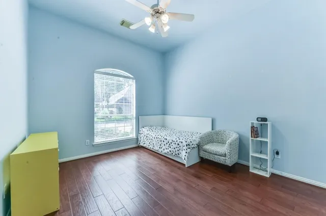 a bedroom with a bed and a chandelier fan
