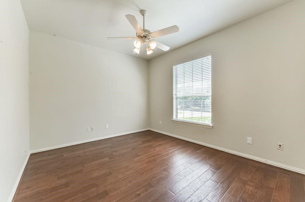 31 North Warbler Bend Circle Spring, TX 77382 - Photo 25 of 31 a view of an empty room with wooden floor and a window