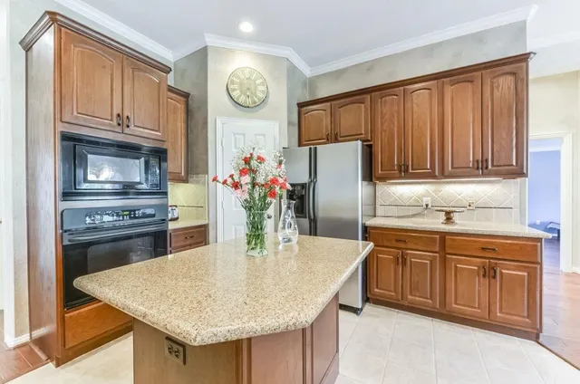 a kitchen with stainless steel appliances granite countertop a kitchen island a stove a refrigerator a oven a sink with island and chairs