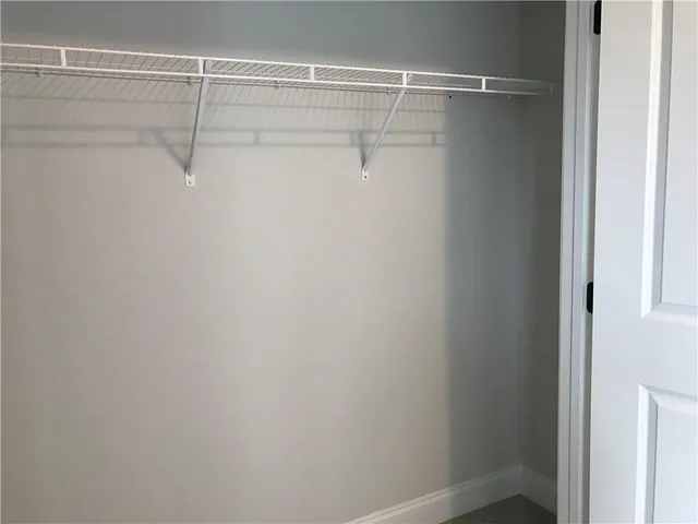 a view of a hallway with wooden floor and a window