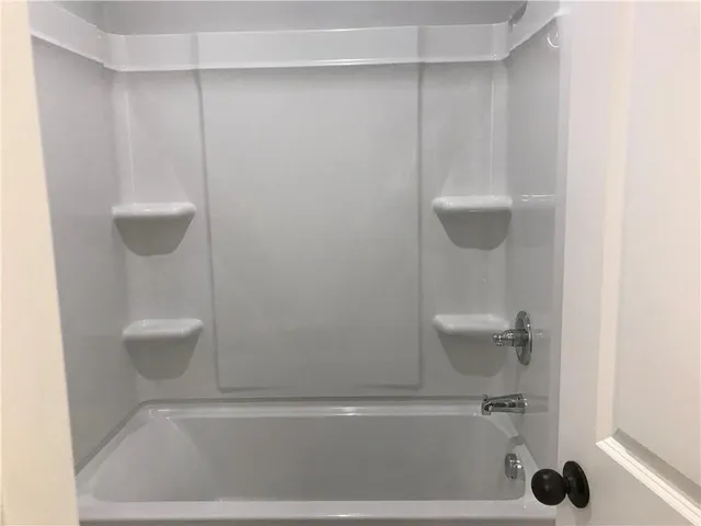 an empty room with wooden floor fireplace and windows