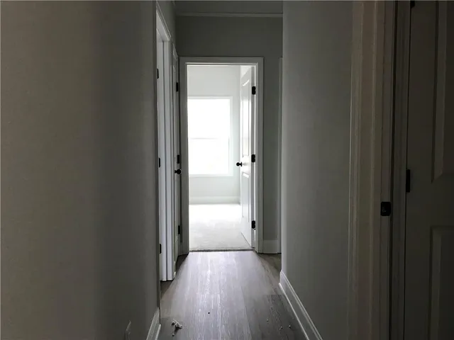 an empty room with wooden floor a fire place and windows