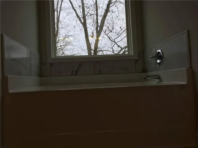 an empty room with wooden floor fireplace and windows