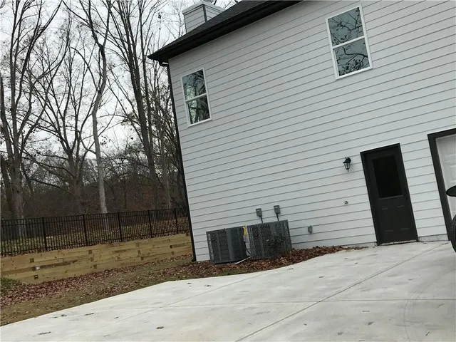 a view of a white house with a small yard and furniture