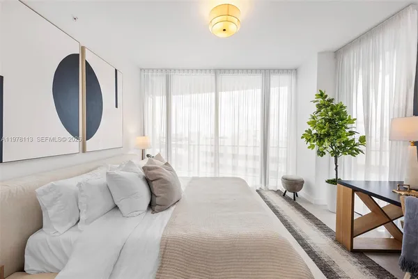 a bedroom with a bed and a chandelier
