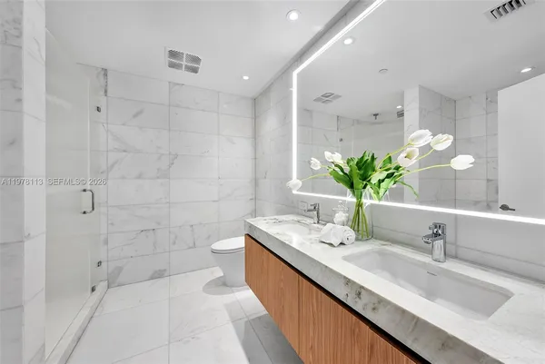 a bathroom with a granite countertop sink a mirror and a bathtub