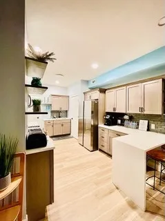 a kitchen with a refrigerator a stove top oven a sink and cabinets