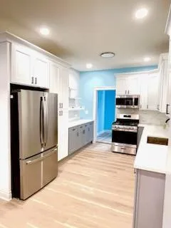 a kitchen with granite countertop a refrigerator and a stove top oven