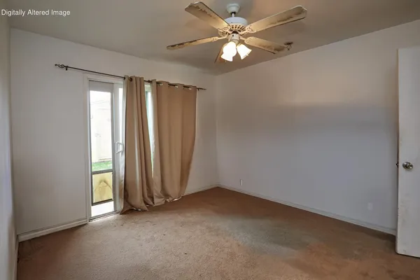 an empty room with windows and fan