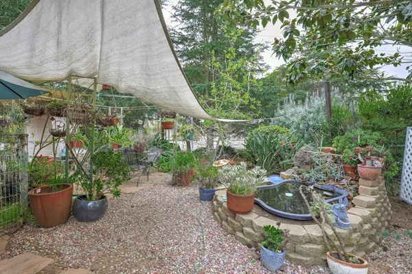 a view of a patio with table and chairs potted plants