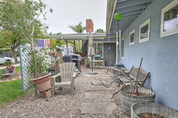 a view of a patio with furniture and a garden