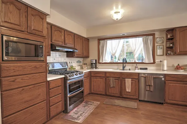 a kitchen with stainless steel appliances granite countertop a stove and cabinets