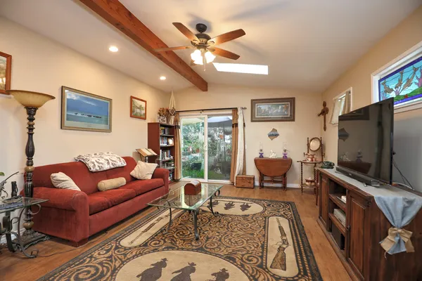 a living room with furniture a flat screen tv and a large window