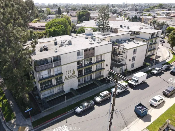 an aerial view of a residential apartment building with a yard and seating area
