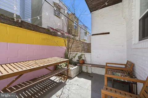 a view of a patio with wooden chairs