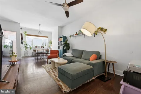 a living room with furniture a rug and white walls