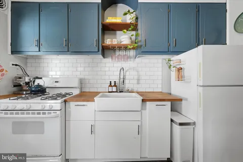 a kitchen with a sink a stove and cabinets