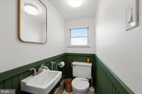 a bathroom with a toilet a sink a mirror and vanity