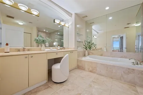a bathroom with a tub a sink and mirror