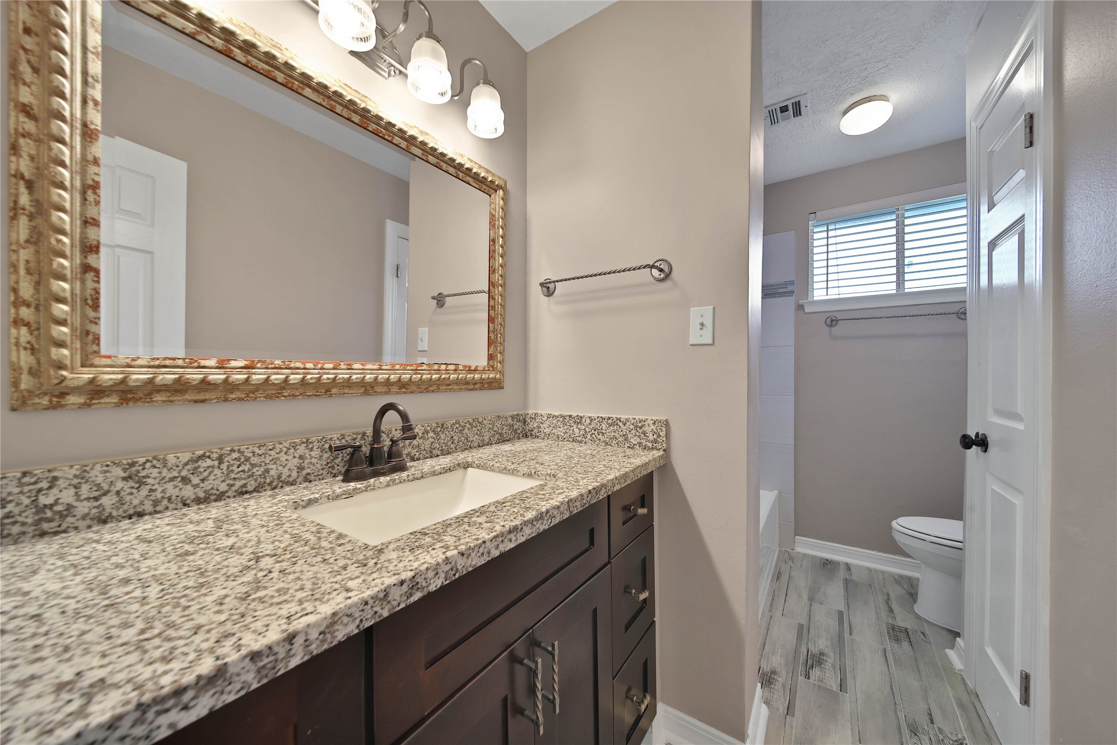 2006 Mermaid Lane Houston, TX 77062 - Photo 26 of 35 a bathroom with a granite countertop sink a toilet and a mirror