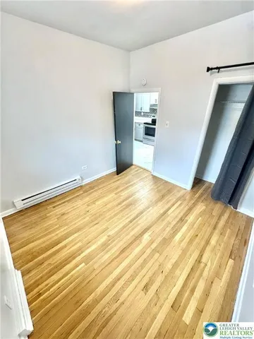 a view of empty room with wooden floor