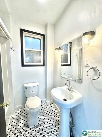 a bathroom with a toilet a sink and a mirror