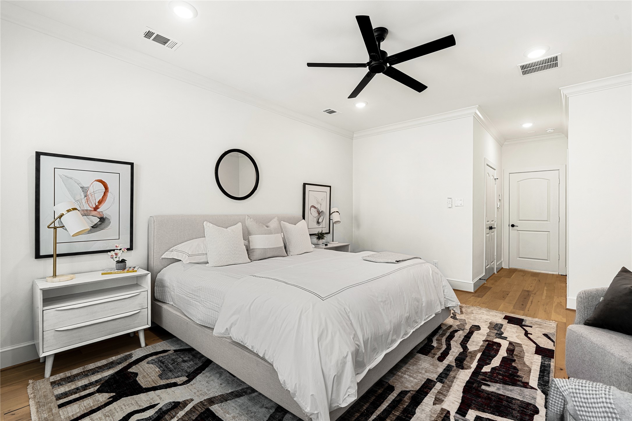 1614 Ojeman Road, Unit E Houston, TX 77055 - Photo 30 of 50 Modern, minimalist design with neutral tones. It includes a comfortable king-sized bed, and a ceiling fan. Natural light highlights the hardwood floors and ample recessed lighting.