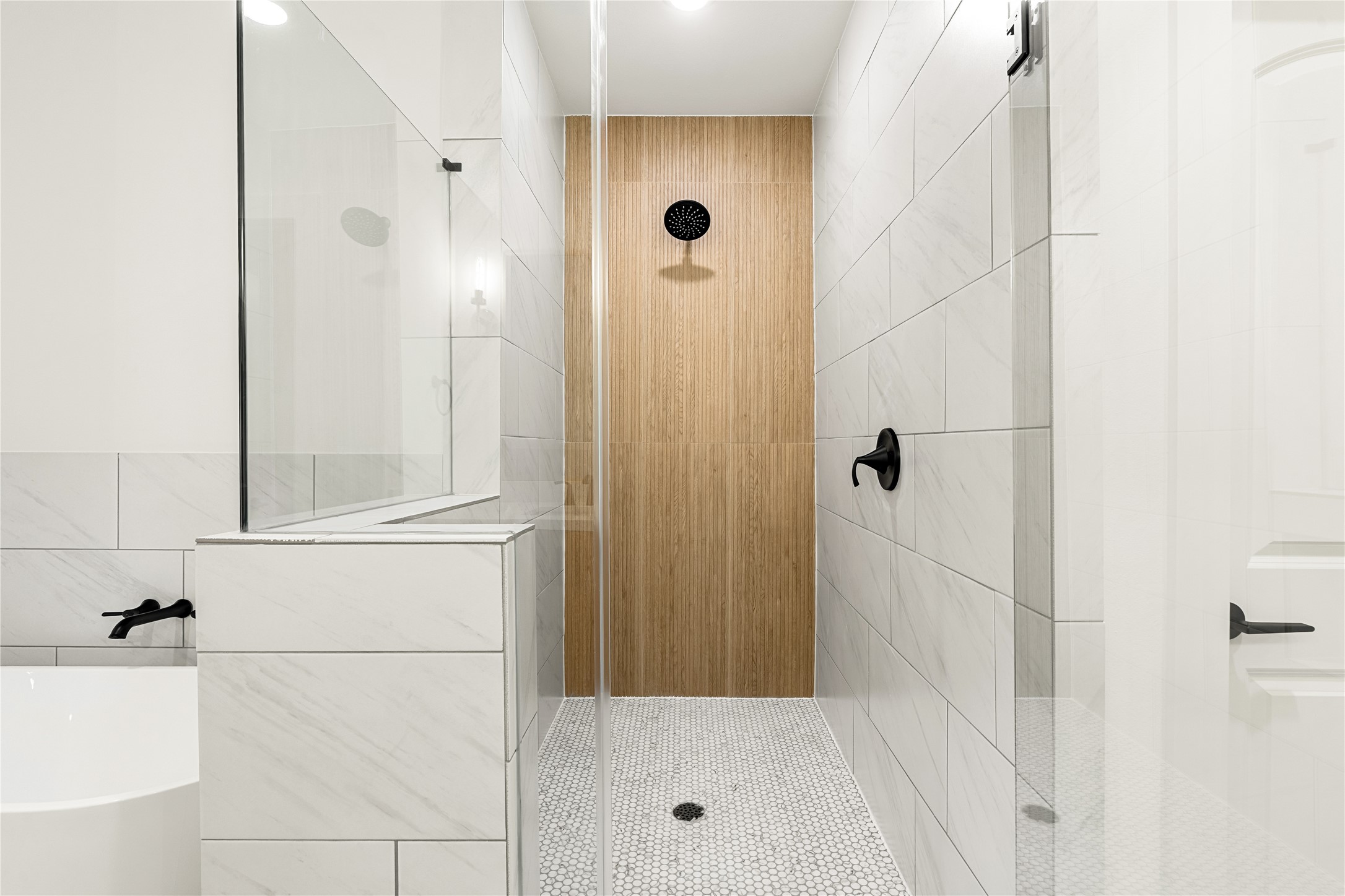1614 Ojeman Road, Unit E Houston, TX 77055 - Photo 36 of 50 Luxurious walk-in shower featuring sleek white tiles, a stylish wood accent wall, and a built-in niche for conveniently storing your essentials.