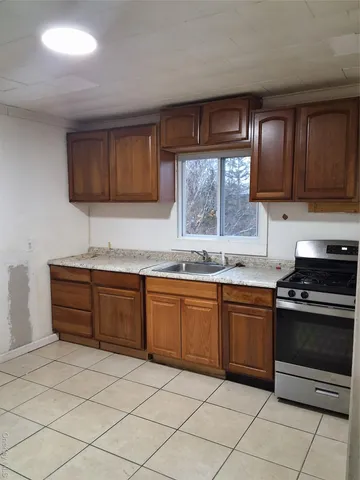 a kitchen with granite countertop wooden cabinets and a stove top oven