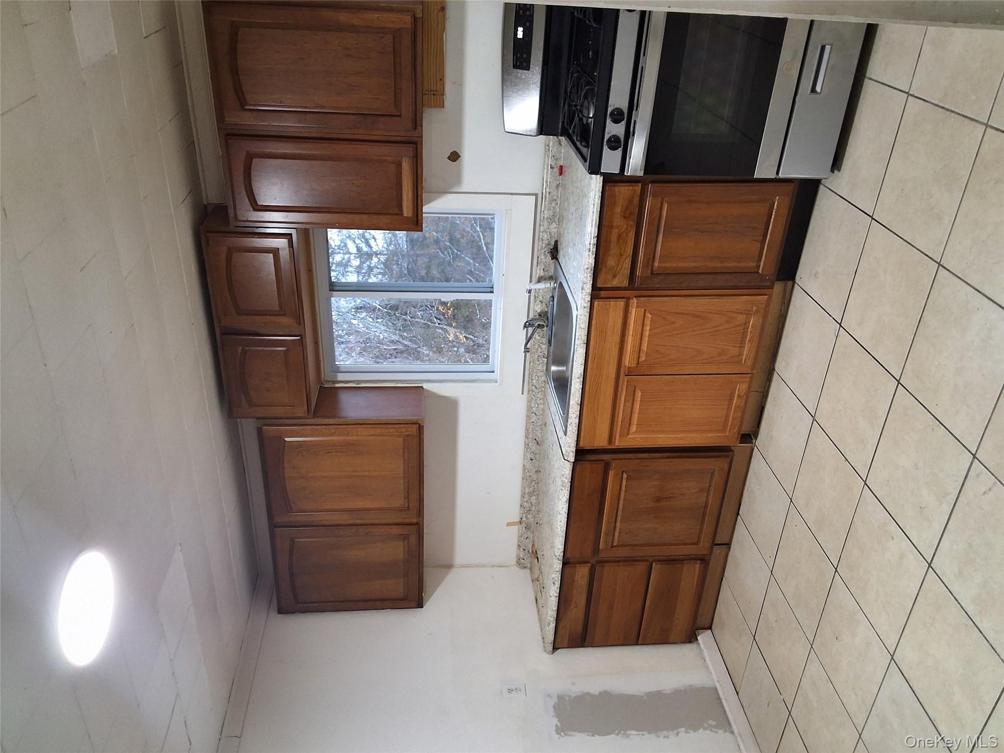 84 North Road Bloomingburg, NY 12721 - Photo 5 of 14 a kitchen with granite countertop wooden cabinets and a stove top oven