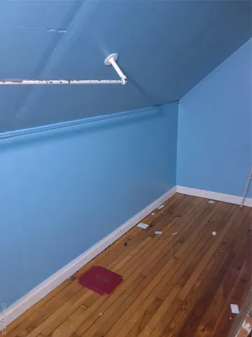 a view of a room with wooden floor and white walls