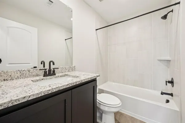 a bathroom with a granite countertop sink toilet and shower