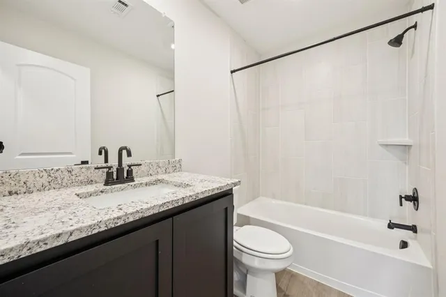 a bathroom with a granite countertop sink toilet and shower
