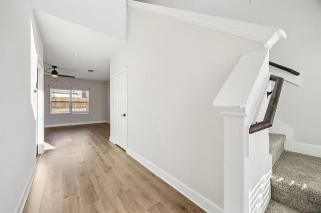 a view of a hallway view with wooden floor and staircase