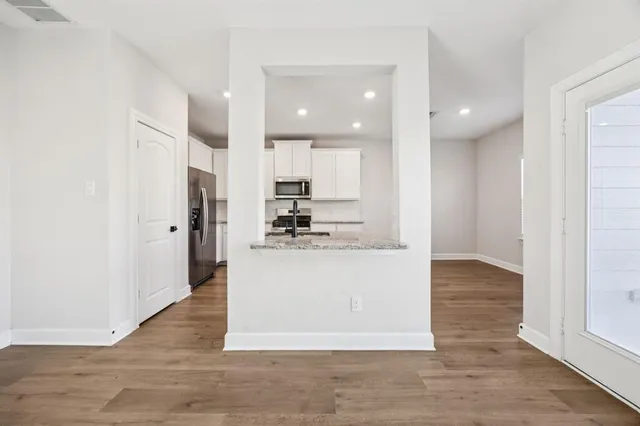a view of kitchen with kitchen island stainless steel appliances refrigerator stove microwave and cabinets