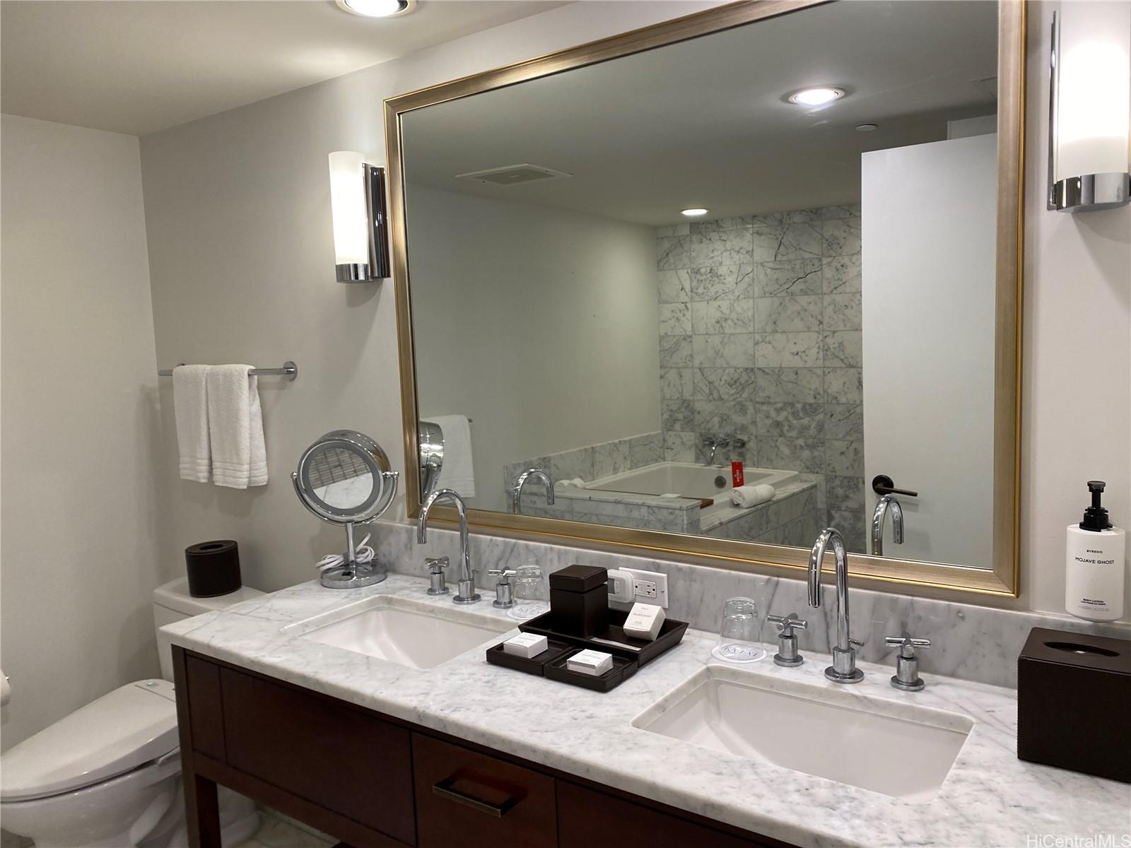 223 Saratoga Road, Unit 2316 Honolulu, HI 96815 - Photo 12 of 20 a bathroom with a granite countertop sink a mirror and shower