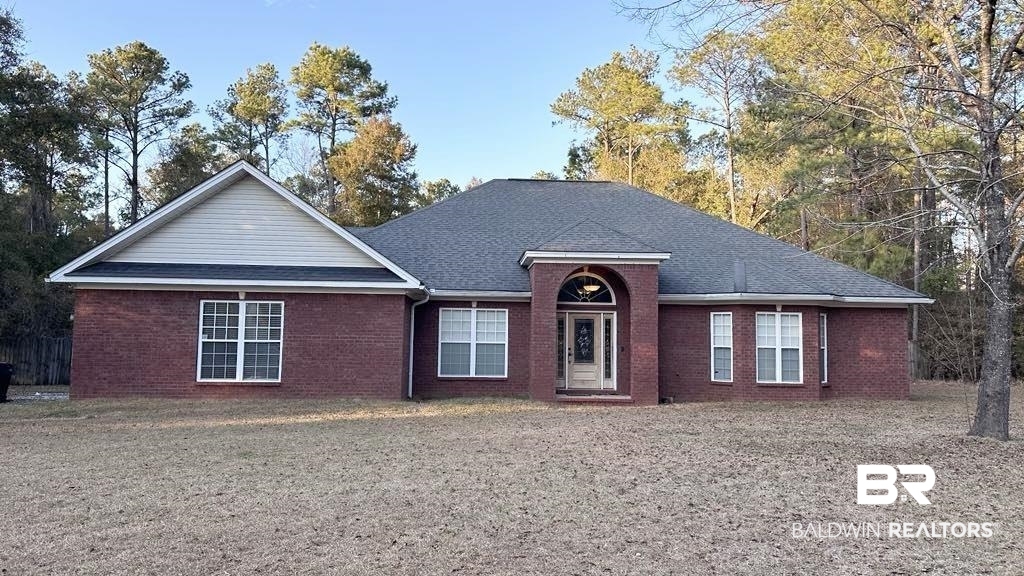 23289 McPhillips Road Loxley, AL 36551 - Photo 2 of 19 Brick exterior featuring a gabled roofline, dark shingle roof, and light-colored siding accents