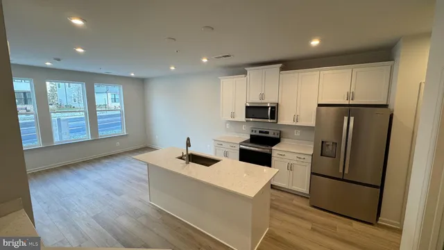 a view of a big room with wooden floor and windows