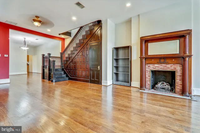 a view of a livingroom with wooden floor and a fireplace