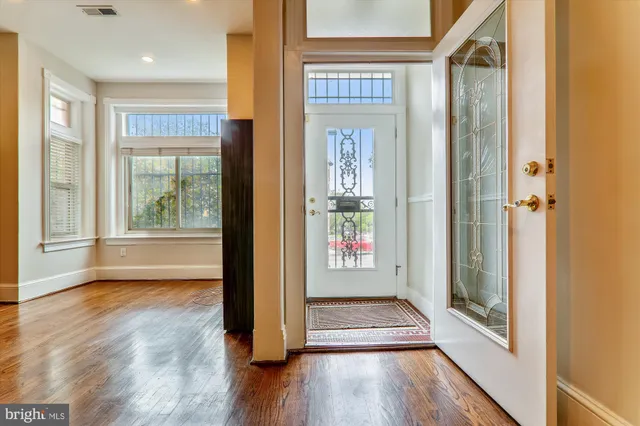 a view of a hallway with wooden floor and windows